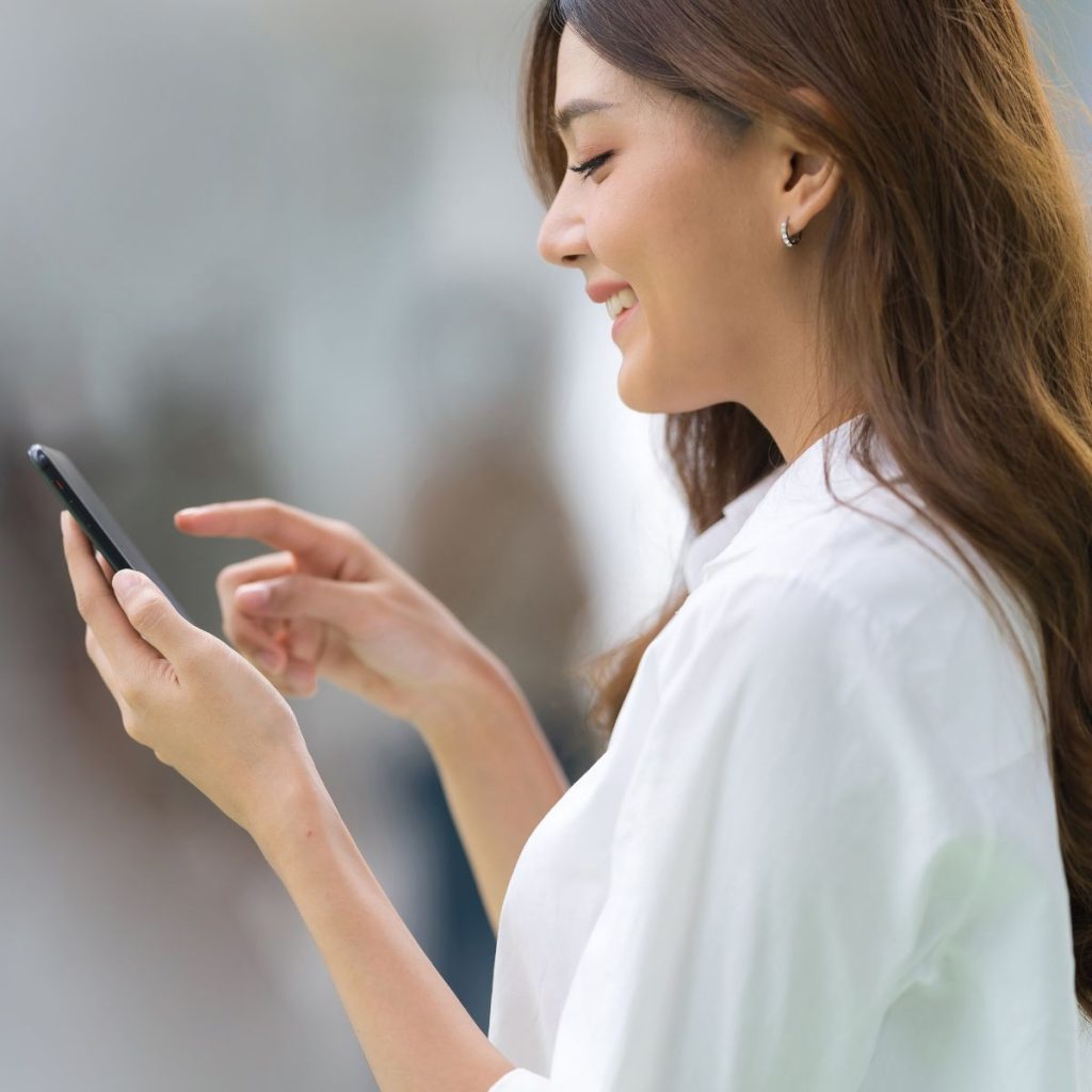 Woman smiling while looking at phone