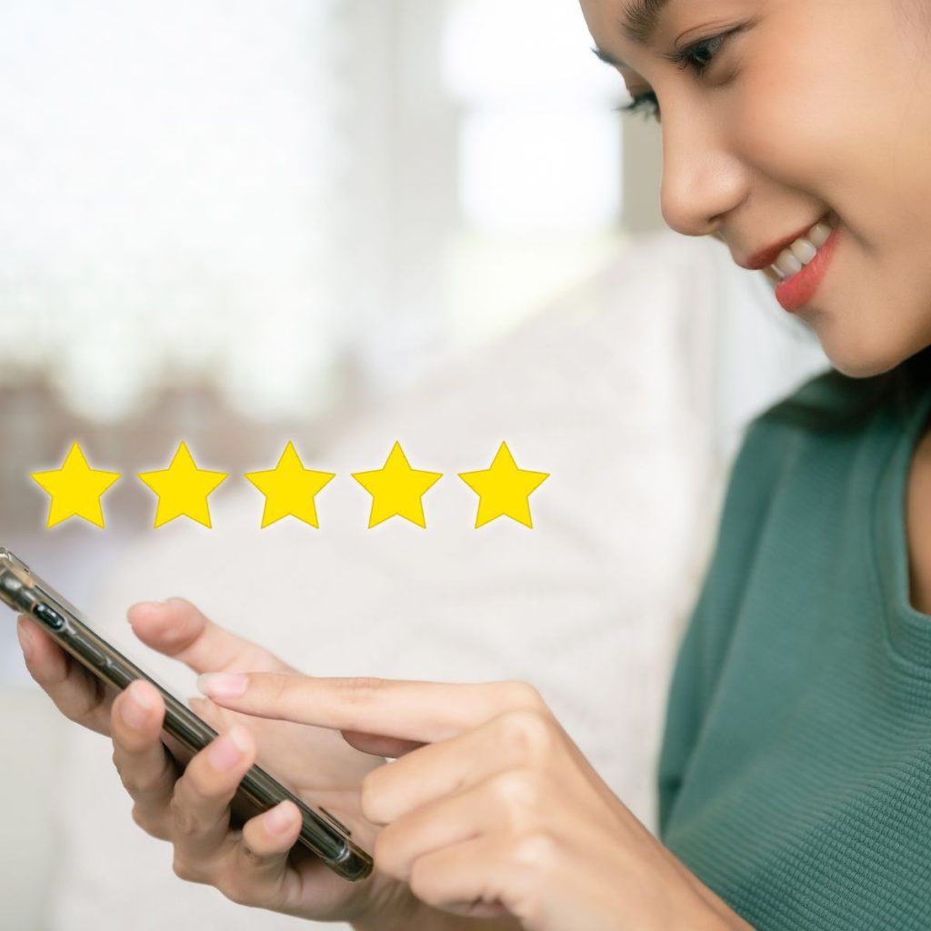 Woman using a smartphone with a floating 5 star rating icon