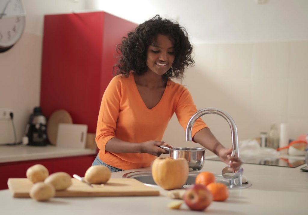 a lady pouring water into a pot