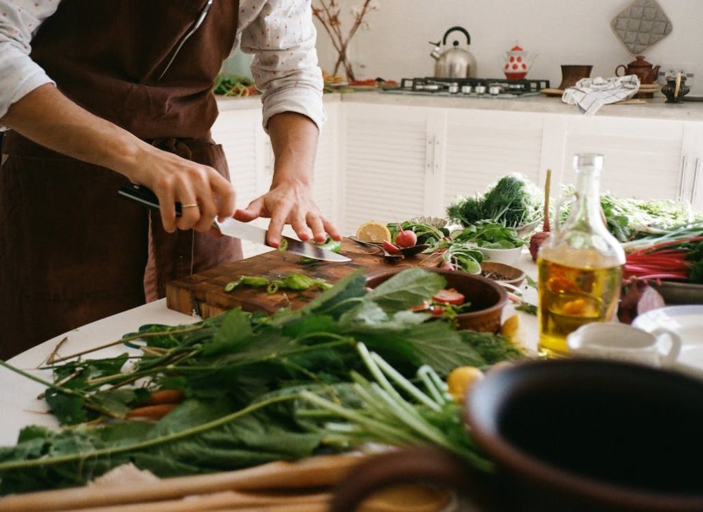 chef's knife being used to cut vegetables