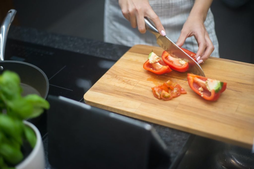 Best Kitchen Knife Sets Under $100 featuring someone cutting a bell pepper