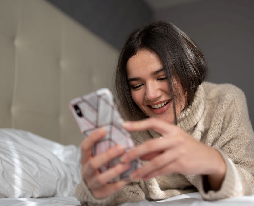 lady smiling browsing a smartphone