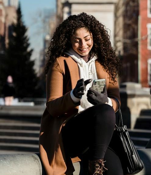 lady smiling looking at her smartphone