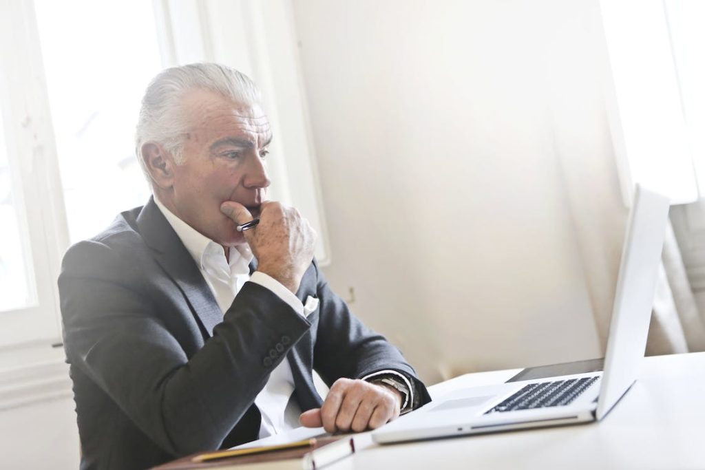 is tripadvisor business free featuring a man in suit thinking looking at the laptop screen