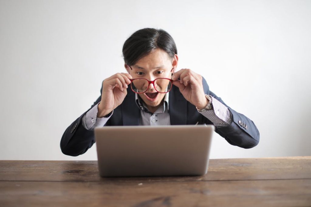 man surprised looking at the laptop screen