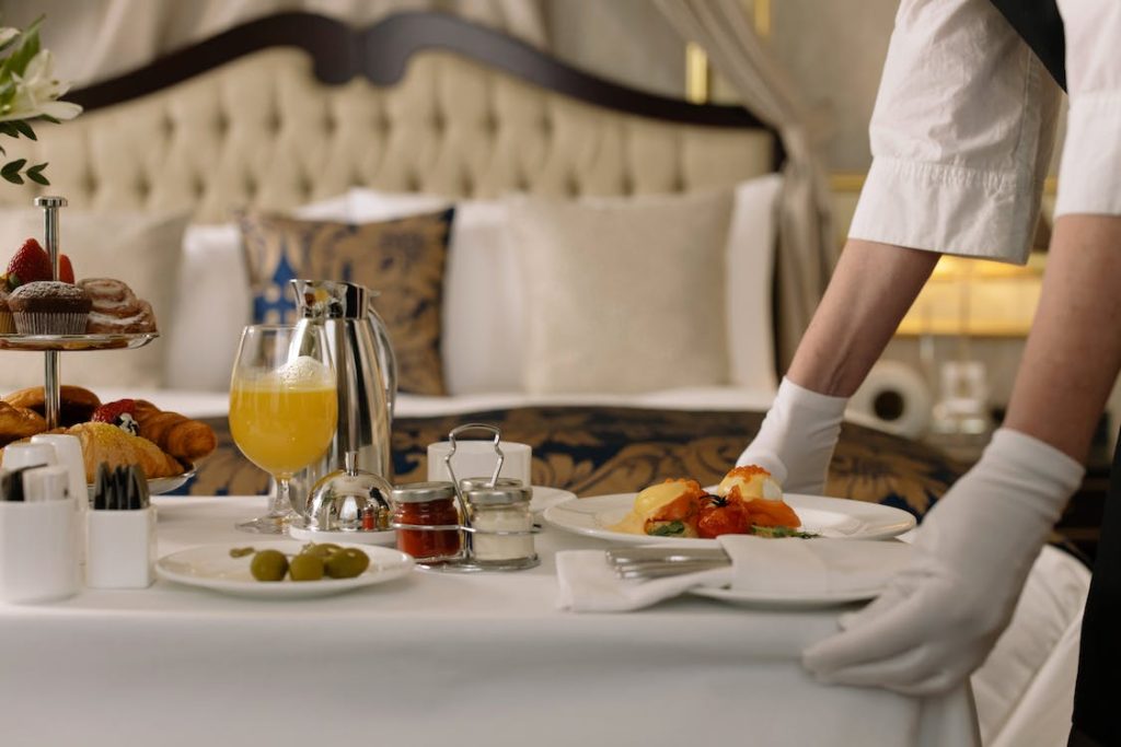 staff setting up food in a hotel room