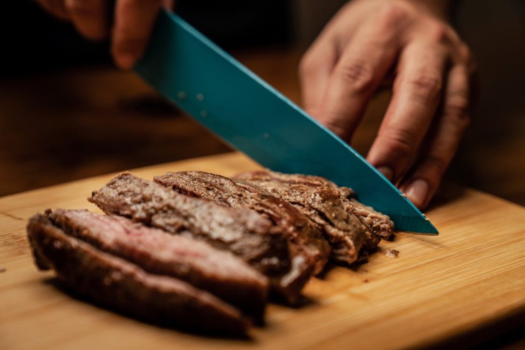 slicing cooked meat on a chopping board