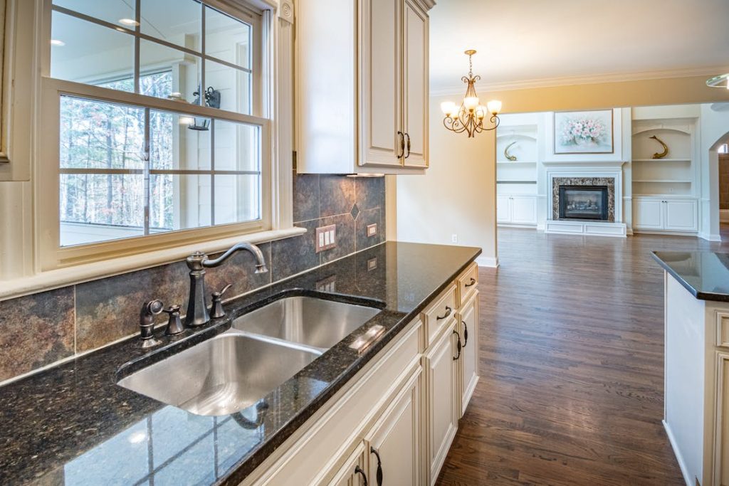 a stainless sink in a white themed kitchen