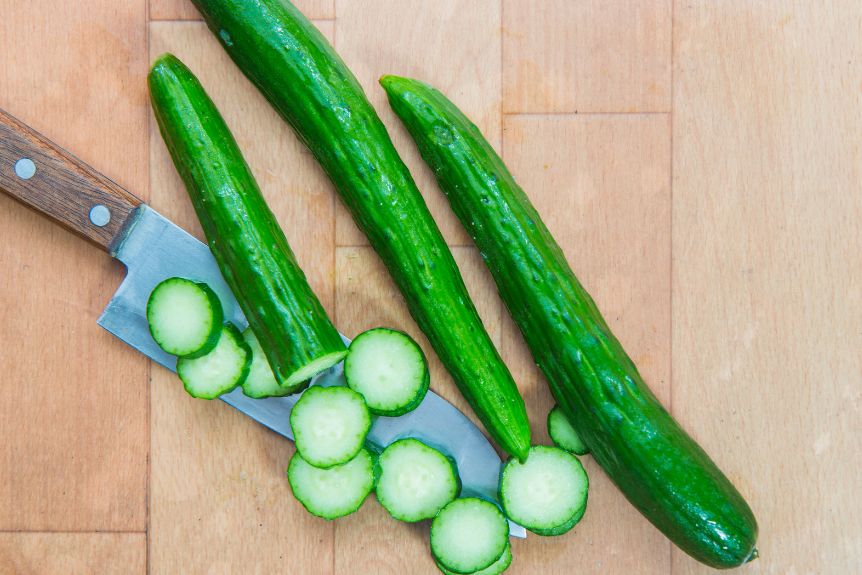 Slices of Japanese cucumbers on top of a knife.