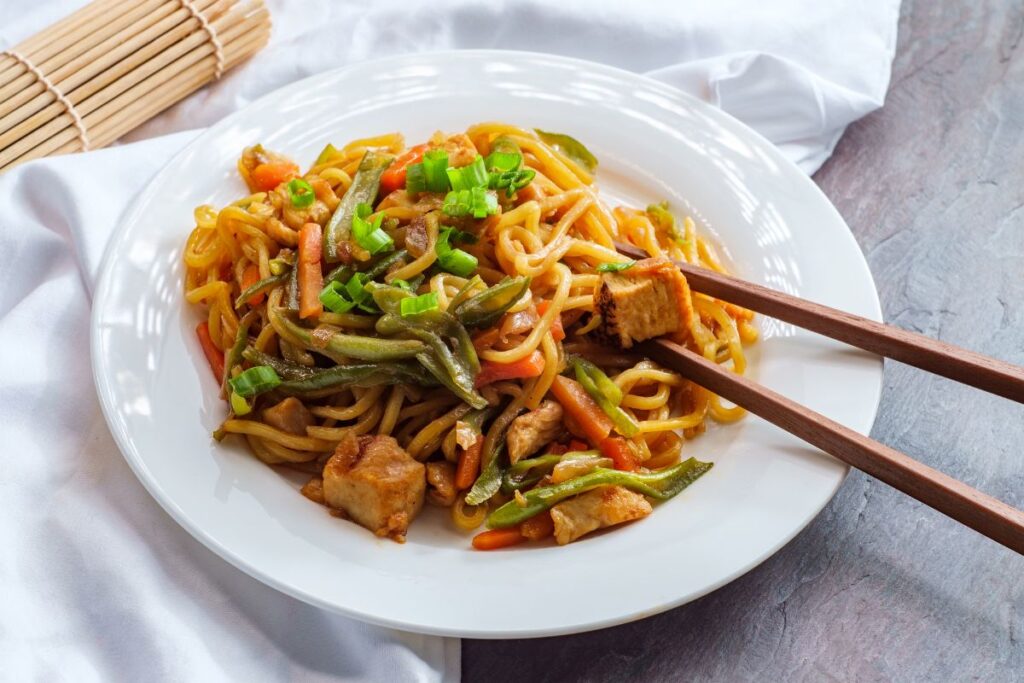 yakisoba noodles on a plate with chopsticks