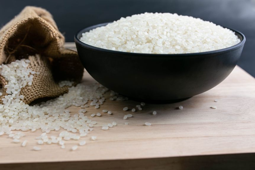 Japanese rice varieties in a bowl and on top of a wooden board.